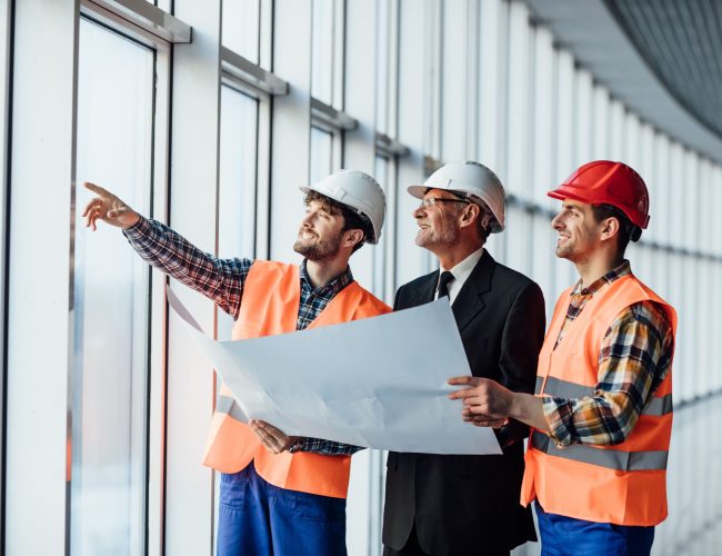 architect-man-showing-something-project-his-colleague-foreman