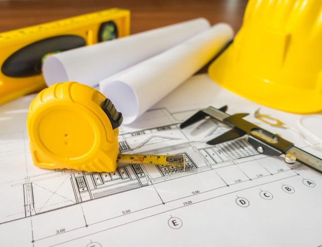 construction-plans-with-yellow-helmet-drawing-tools-bluep(1)